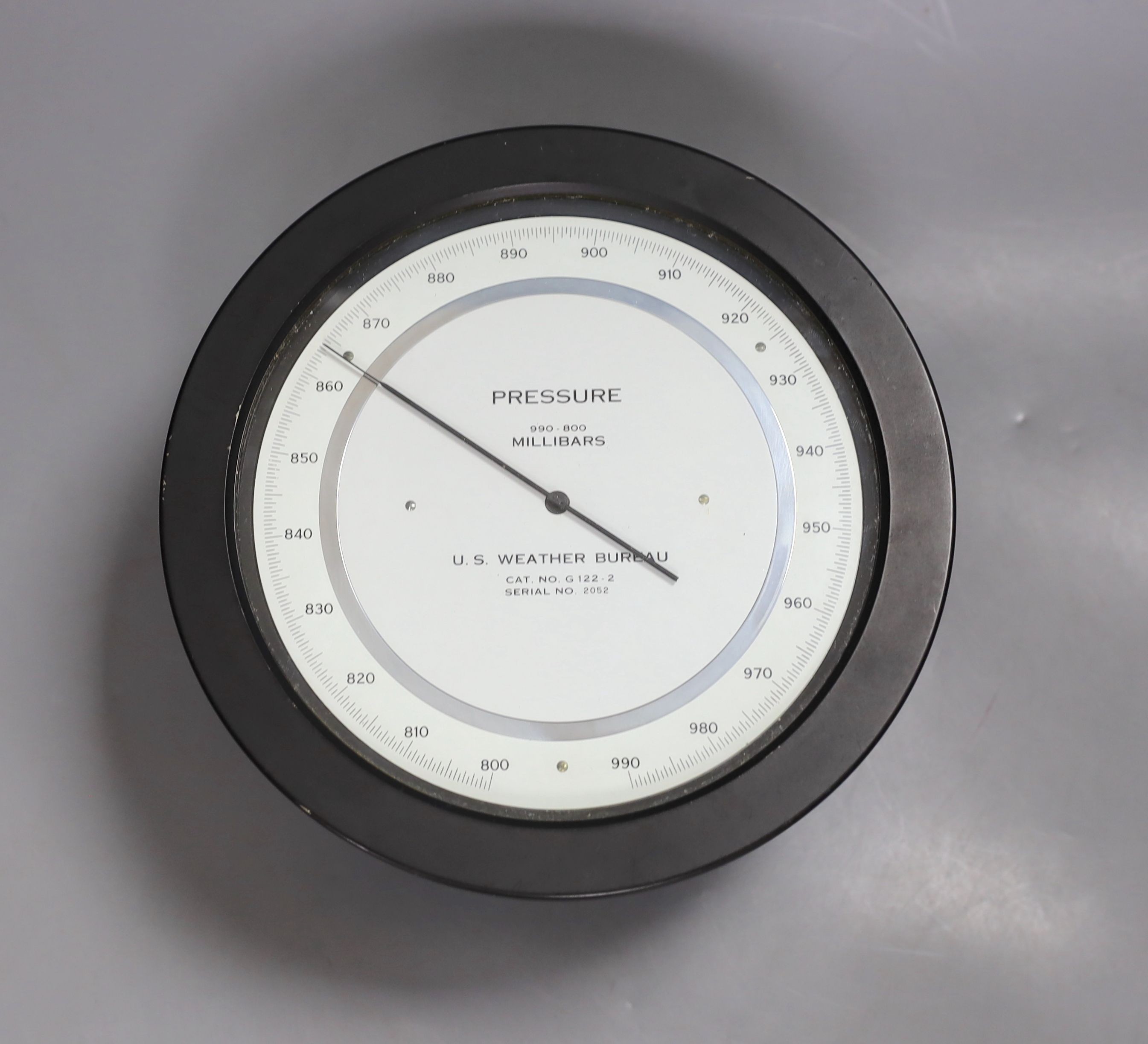 A U.S. Weather Bureau barometer , millibars 990-800, serial number 2052, 21 cms diameter.